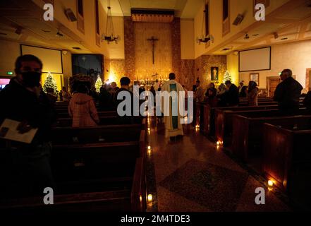 Los Angeles, Kalifornien, USA. 22. Dezember 2022. Der Priester geht während der Rorate Caeli Messe zum Altar, ein 'vergessener Advent traditionÃ', der der Jungfrau Maria geehrt ist, in der katholischen Kirche unserer Gnaden in Encino, Kalifornien Diese Massen, die in der Regel wenige Tage vor Weihnachten gefeiert werden, zeichnen sich dadurch aus, dass sie nur von Kerzenlicht beleuchtet werden, im Dunkeln gefeiert werden und von gregorianischen Gesängen und heiliger Musik begleitet werden. (Kreditbild: © Jill Connelly/ZUMA Press Wire) Stockfoto