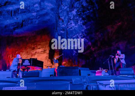 Castellana Grotte, Italien. 21. Dezember 2022. Giuliano Sangiorgi singt die „Sterne“ in der Caverna della Grave delle Grotte di Castellana, begleitet von Raffaele Casaranos Saxophon, für „Weihnachten in den Höhlen“ am 21. Dezember 2022. (Foto: Mimmo Lamacchia/NurPhoto) Guthaben: NurPhoto/Alamy Live News Stockfoto