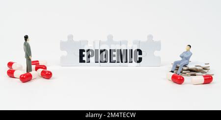Medizinisches Konzept. Auf der weißen Oberfläche der Tablette, Miniatur-menschliche Figuren und Rätsel mit der Inschrift - EPIDEMIE Stockfoto
