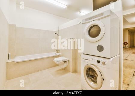Ein Waschraum mit Waschmaschine und Badewanne in der Ecke, neben einer  großen weißen Wanne Stockfotografie - Alamy