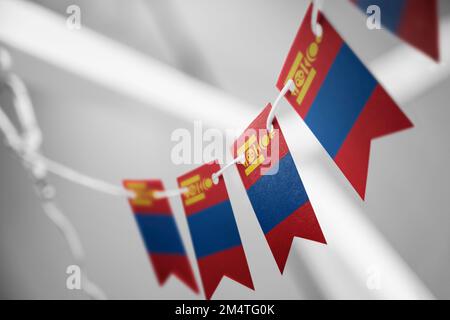 Eine Girlande mongolischer Nationalflaggen auf abstraktem, verschwommenem Hintergrund. Stockfoto