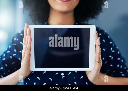 Alle laden es herunter. Eine junge Frau, die ein digitales Tablet mit einem leeren Bildschirm in der Hand hält. Stockfoto