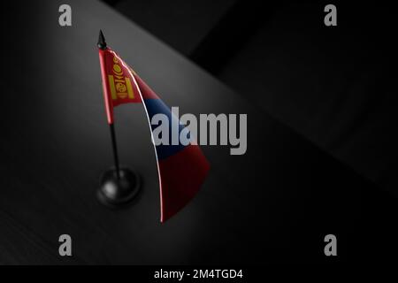 Kleine Nationalflagge der Mongolei auf schwarzem Hintergrund. Stockfoto