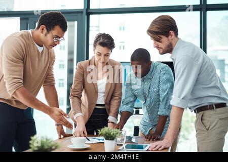 Behalten ihr gemeinsames Ziel im Auge. Eine Gruppe von Geschäftsleuten, die sich in einem Büro unterhalten. Stockfoto