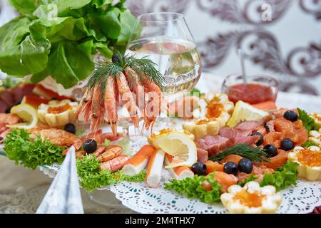 Meeresfrüchte auf dem Teller - Riesengarnelen, Muscheln, Krabbenstangen, Kaviar und Forelle Stockfoto