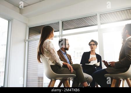 Das ist es, was für uns funktioniert. Eine Gruppe von Geschäftsleuten, die in einer Besprechung sitzen. Stockfoto