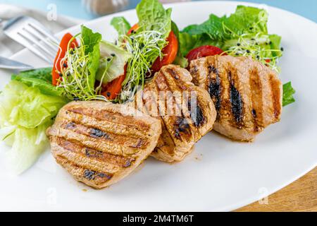 Fleisch mit Gemüse. Schweinemedaillons. Gegrilltes Fleisch. Cutlets close-up. Rindfleisch Stockfoto