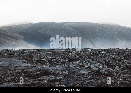 Dramatische Aussicht auf noch heiße Lavafelsen und Dampf, der aus dem heißen Gelände aufsteigt Stockfoto