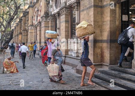 Gepäckträger mit Fischkörben auf dem Kopf, am Chhatrapati Shivaji Maharaj Terminus (CMST) in Mumbai, Indien, um die Körbe mit dem Zug weiterzuleiten Stockfoto