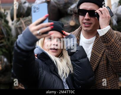 Krakau, Polen - 19. Dezember 2021: Margaret und Dawid Kwiatkowski während der Verteilung von Weihnachtsbäumen am Szczepanski-Platz in Krakau Stockfoto