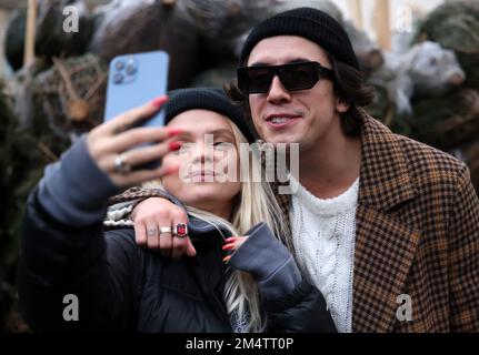 Krakau, Polen - 19. Dezember 2021: Margaret und Dawid Kwiatkowski während der Verteilung von Weihnachtsbäumen am Szczepanski-Platz in Krakau Stockfoto