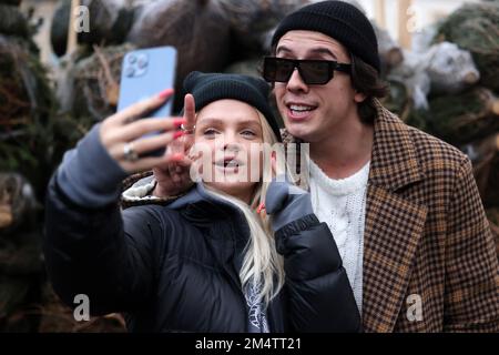 Krakau, Polen - 19. Dezember 2021: Margaret und Dawid Kwiatkowski während der Verteilung von Weihnachtsbäumen am Szczepanski-Platz in Krakau Stockfoto