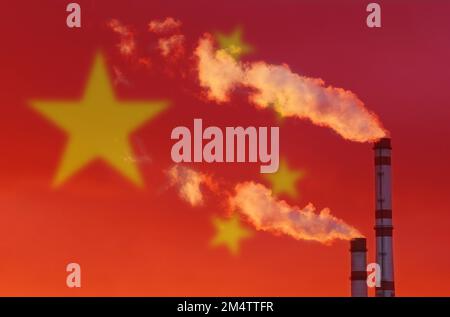 Ökologisches Konzept. Vor dem Hintergrund der chinesischen Flagge aus den Rohren eines Industrieunternehmens verunreinigt Rauch die Luft Stockfoto