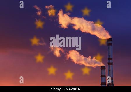 Ökologisches Konzept. Vor dem Hintergrund der Flagge der Europäischen Union gibt es Rauch aus den Rohren eines Industrieunternehmens, der die verschmutzt Stockfoto