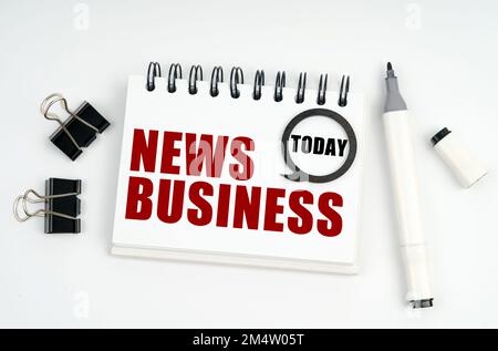 Geschäftskonzept. Auf einer weißen Oberfläche liegen ein Marker, Clips und ein Notizbuch mit den Aufschriften Today and NEWS BUSINESS Stockfoto