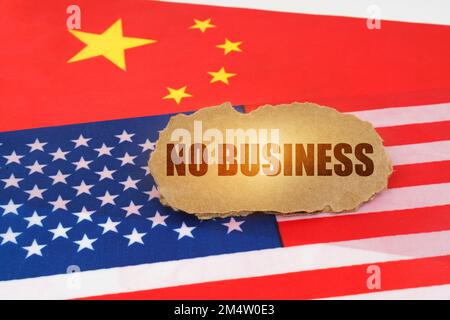 Politisches Konzept. Auf den Flaggen der USA und Chinas liegt ein Pappschild mit der Aufschrift "No Business" Stockfoto