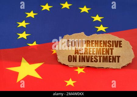 Politisches Konzept. Auf den Flaggen Chinas und der Europäischen Union befindet sich ein Pappschild mit der Aufschrift "umfassendes Investitionsabkommen" Stockfoto