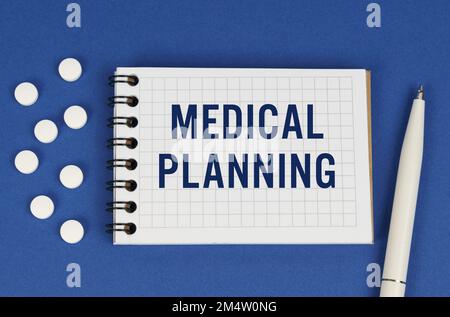 Medizinisches Konzept. Auf blauem Hintergrund, einem Stift, Tabletten und einem Notizblock mit der Inschrift - MEDIZINISCHE PLANUNG Stockfoto