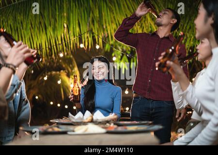 Junge Asiaten, die auf der Party anstoßen Stockfoto