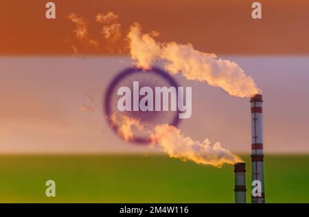 Ökologisches Konzept. Vor dem Hintergrund der indischen Flagge tritt Rauch aus den Schornsteinen eines Industrieunternehmens aus, der die Luft verschmutzt. Stockfoto