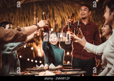 Eine Gruppe von Menschen, die im Garten im Freien feiern, indem sie Bier trinken Stockfoto