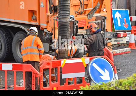 Nahaufnahme eines gemieteten LKW-Fahrers mit Saugbagger in schwarzer Jacke steuert alle Maschinenbewegungen über die Fernbedienung England UK Stockfoto