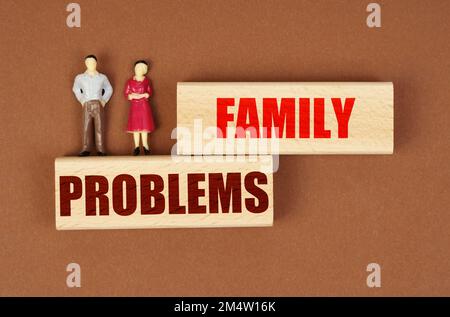 Gesetz und Menschenverstand. Auf Holzblöcken mit der Inschrift "Familienprobleme" sind Miniaturfiguren von Menschen. Stockfoto