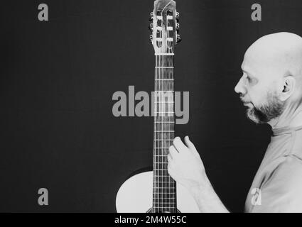 Eine Graustufenaufnahme eines charismatischen, kaukasischen männlichen Gitarrist Stockfoto