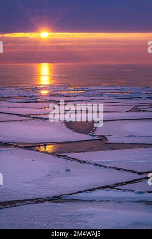 Eisschollen auf dem Lake Superior, während die Winterpause bei einem atemberaubenden Sonnenaufgang über den größten der Großen Seen auf der oberen Halbinsel von Michigan beginnt Stockfoto