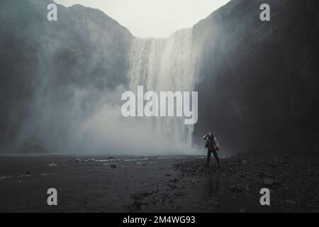 Frau in der Nähe von Skogafoss Wasserfall Landschaftsfoto Stockfoto