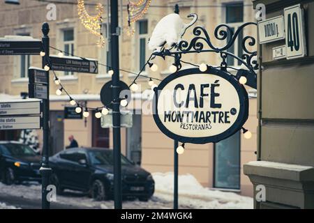 Gemütliches Vintage Cafe Montmartre, Restaurant oder Café in der Altstadt von Vilnius, Litauen an einem kalten Wintertag mit Schnee, Glühbirnen und Lichtern in Vilnius Stockfoto
