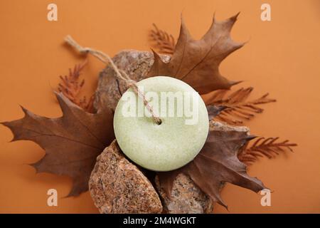 Handgefertigte Solid Dry Shampoos mit runder Form auf Herbsthintergrund. Natürliche Haarkosmetik. Seifenhandwerk. Umweltfreundliche Produkte, kein Abfall Stockfoto