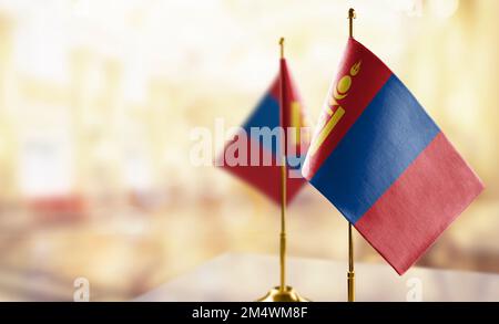 Kleine Flaggen der Mongolei auf abstraktem, verschwommenem Hintergrund. Stockfoto