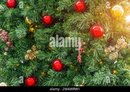Die Textur der grünen Fichte und die Dekoration rote Kugeln, Zapfen und Beeren, weihnachtshintergrund Stockfoto