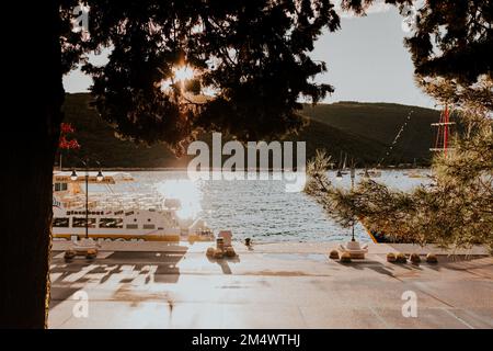 Landschaft an einem Yachthafen umgeben von Bergen und Booten im Sommer bei Sonnenuntergang Stockfoto