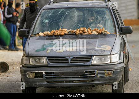 Nablus, Palästina. 23. Dezember 2022. Ein maskierter palästinensischer Protestteilnehmer wurde während der Demonstration gegen israelische Siedlungen im Dorf Kafr Qaddoum in der Nähe der Stadt Nablus im Westjordanland gesehen. Kredit: SOPA Images Limited/Alamy Live News Stockfoto