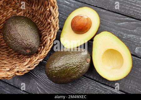 Abgeschnittene hass Avocado auf Holz, Blick von oben Stockfoto