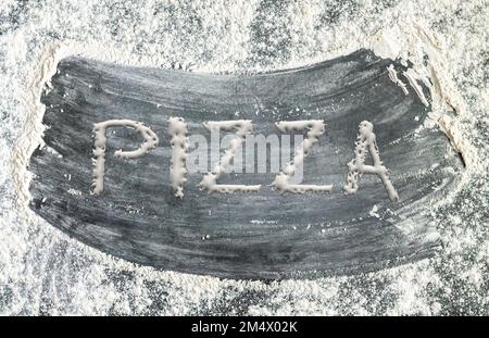 Backhintergrund mit Wort PIZZA, geschrieben mit Mehlteig. Italienisches Speisekonzept Stockfoto