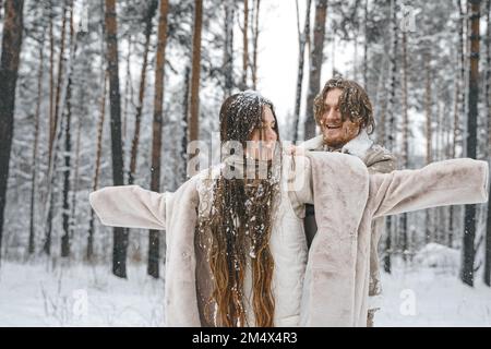 Romantische Schnee Liebe Story.Young paar Kerl Mädchen liegen, spielen im verschneiten Winterwald mit trees.Walking, Spaß haben, lachen in stilvollen warmen Kleidung, Stockfoto