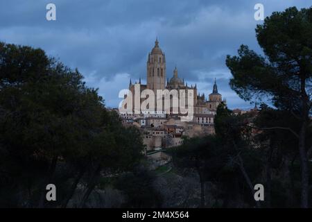 Segovia, Spanien - 4. Januar 2022: Panoramablick auf Segovia mit den Türmen der Kathedrale und dem dramatischen Himmel in der Dämmerung Stockfoto