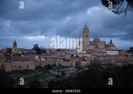 Segovia, Spanien - 4. Januar 2022: Panoramablick auf Segovia mit den Türmen der Kathedrale und dem dramatischen Himmel in der Dämmerung Stockfoto