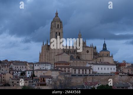 Segovia, Spanien - 4. Januar 2022: Panoramablick auf Segovia mit den Türmen der Kathedrale und dem dramatischen Himmel in der Dämmerung Stockfoto