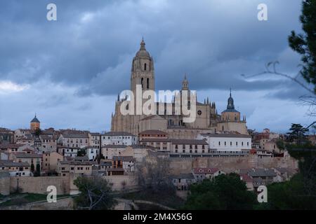 Segovia, Spanien - 4. Januar 2022: Panoramablick auf Segovia mit den Türmen der Kathedrale und dem dramatischen Himmel in der Dämmerung Stockfoto