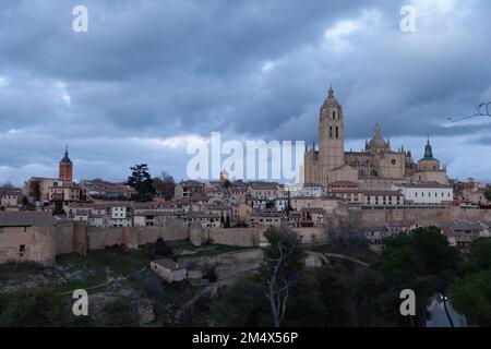 Segovia, Spanien - 4. Januar 2022: Panoramablick auf Segovia mit den Türmen der Kathedrale und dem dramatischen Himmel in der Dämmerung Stockfoto