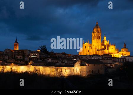 Segovia, Spanien - 4. Januar 2022: Panoramablick auf Segovia mit den Türmen der Kathedrale und dem dramatischen Himmel in der Dämmerung Stockfoto