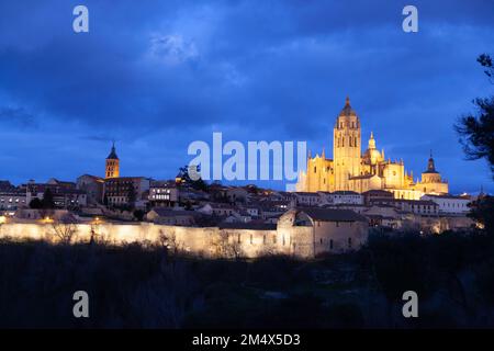 Segovia, Spanien - 4. Januar 2022: Panoramablick auf Segovia mit den Türmen der Kathedrale und dem dramatischen Himmel in der Dämmerung Stockfoto