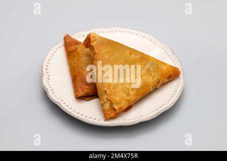 Zwei Samosas mit Fleisch und Gemüse auf einem kleinen weißen Teller Stockfoto