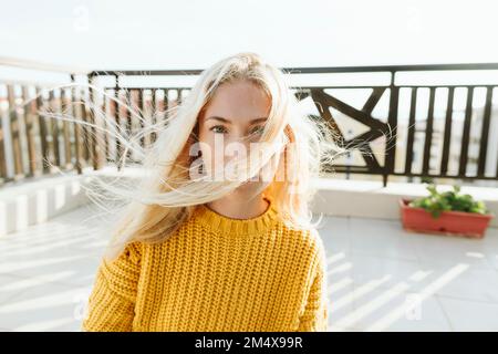 Frau mit windgepeitschtem Haar auf der Terrasse Stockfoto