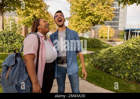 Fröhliche junge Frau mit einem Mann im Park Stockfoto
