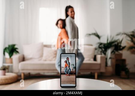 Mutter und Tochter Filmen Videos über Smartphones zu Hause Stockfoto